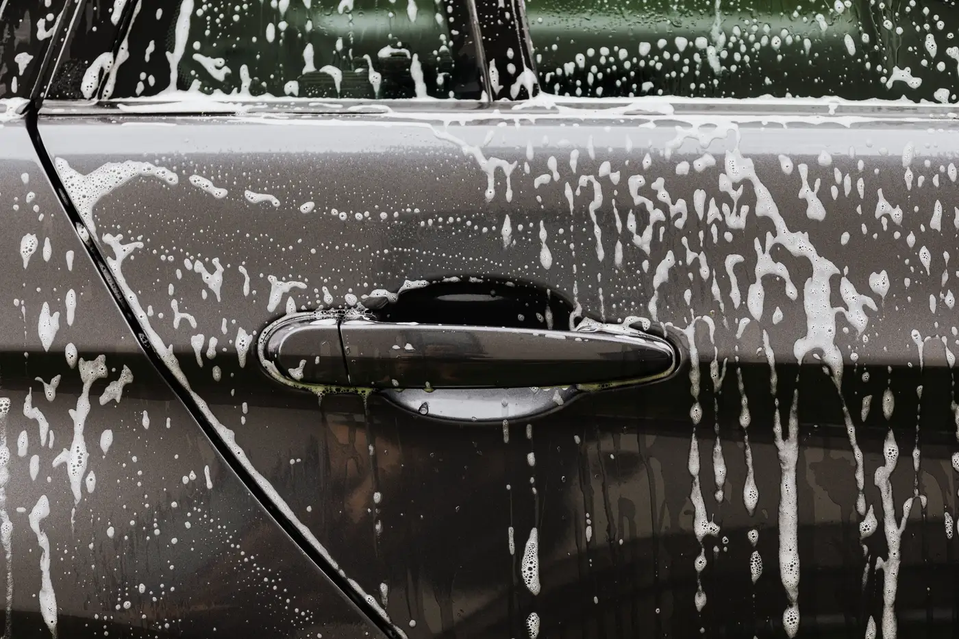 Carrosserie couverte de mousse lors d’un lavage auto à la main à Genève